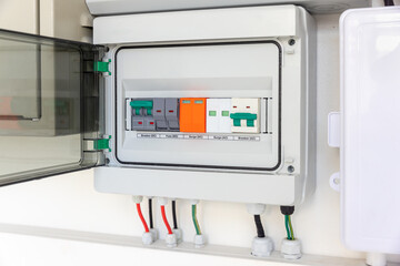 Solar Combiner Box on a House Wall with Integrated DC and AC Safety Components (Breakers, Fuses, Surge Protection) for a Hybrid PV System.
