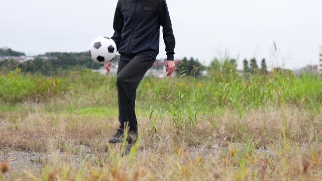 リフティングの練習をするサッカー選手の足元のアップのスローモーション
