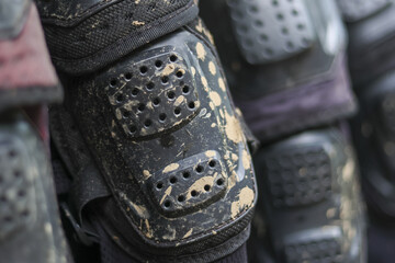 Close up view of dirty, muddy protective gear. Tactical armor equipment like knee pad after an...