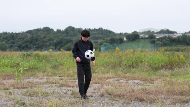 リフティングの練習をするサッカー選手