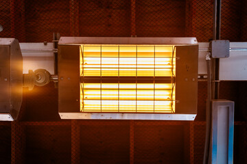 Industrial Radiant Heater With Grid Guard Illuminated Tubular Lamps In Ceiling Fixture