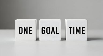 Focused business concept with white blocks spelling ONE GOAL TIME, emphasizing productivity and achieving success efficiently