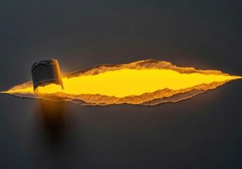 A hole in the dark surface revealing a bright yellow light underneath it