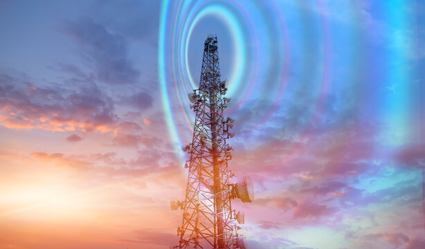 Antenna tower of telecommunication and Phone base station with TV and wireless internet antennas at sunset