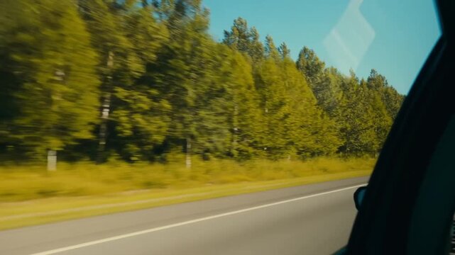 View from a moving vehicle captures a scenic highway, tree-lined road, and bright skies Stock Video