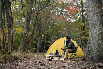 秋のソロキャンプ を楽しむ男性