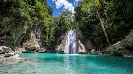 Obraz premium Lush tropical cascade plunges into vibrant turquoise natural pool surrounded by dense foliage