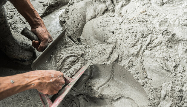 Hand worker mix cement in bucket plaster construction house site background, Concrete mortar mix sand wet with trowel tool well free space for text