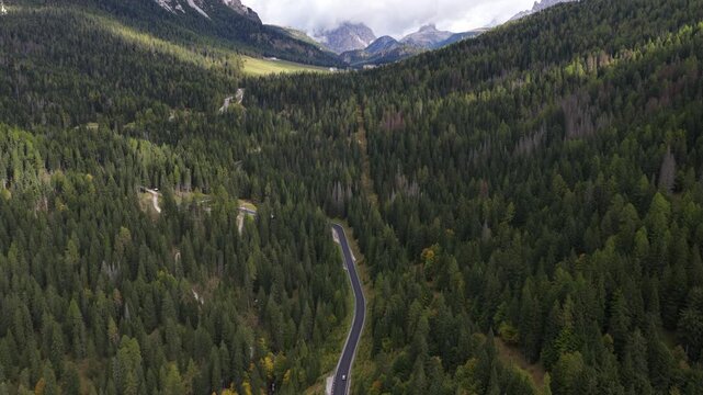 snowy peaks of mountain surrounding the Stelvio Pass, on the border between Switzerland and Italy. Aerial drone video. Beautifull driving serpentine roads over mountain pass.
