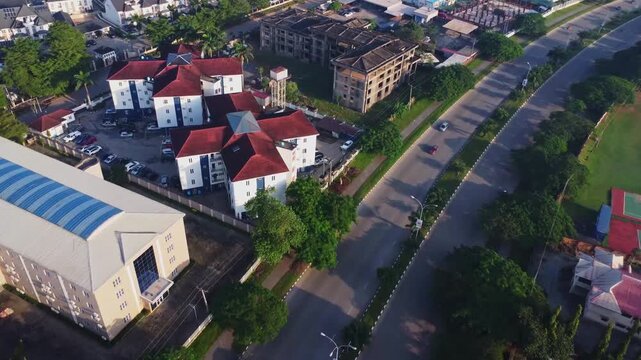 Drone flying towards newly built apartment complexes in the new Gudu neighborhood in Abuja, Nigeria. An uncompleted apartment vidco building can be seen beside.