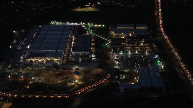 New build data center in Waltham Cross, UK, including data storage, processing, distribution, power, cooling, security, redundancy, maintenance, aerial drone night exterior.