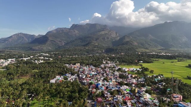 Breathtaking aerial panorama of Courtallam town nestled amid the Western Ghats, surrounded by lush tropical greenery and featuring the iconic Peraruvi waterfall. Perfect for travel or wellness visuals
