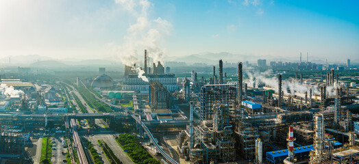 Fototapeta premium Aerial shot of an oil refinery and chemical plant with smoking chimneys in a large industrial area