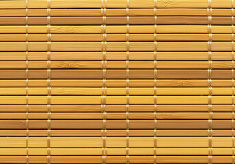 Detailed view of a bamboo mat, showcasing the natural texture and pattern of the wooden slats