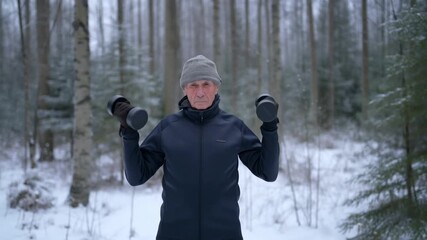 A person lifting dumbbells in a snowy forest, staying fit in the winter Stock Video