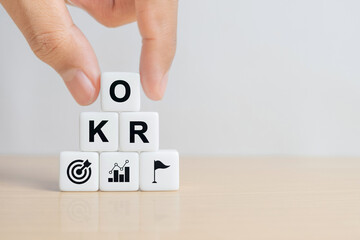 OKR text (Objectives, Key and Results) dice on wooden table. Business target and drive business and performance. Focus on goal. Achieve business growth by flexible management