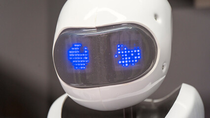 A robot with blue eyes and a white face. The robot is on display in a museum. The robot's eyes are glowing blue, giving it a futuristic and robotic appearance