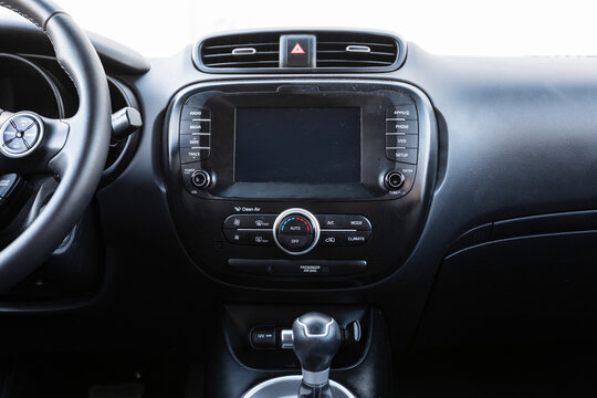 Center console of a 2017 red South Korean hatchback car showing screen, audio system, climate controls vents and dashboard layout in clean interior view. Great for automotive marketing and blogs