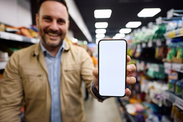 Close up of supermarket customer holding smart phone with blank screen.