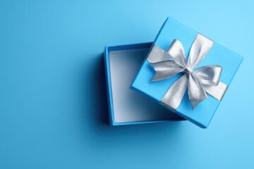 A bright open blue gift box with a silver ribbon bow on a solid blue background