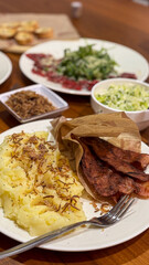 Close-up mashed Potatoes and Crispy Bakon. Golden fried onions crown fluffy potatoes alongside perfectly cooked, savoury strips, creating a hearty and inviting plate for any meal.