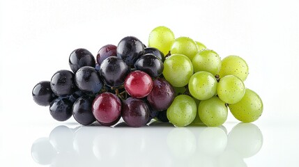 Fresh grapes in various colors arranged on a white surface with water droplets and reflections