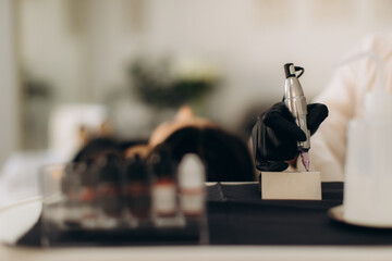 Artist working with permanent makeup tattoo machine