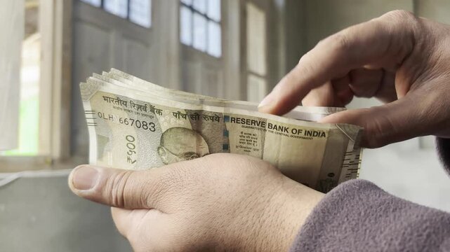 Closeup footage of hands counting cash and money. An employee counting indian rupees or indian currency money which he get from Bank. Person having cash in his hand for billing and payment.