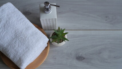 wellness and spa composition with towels, candle, tropical leaves and orchid flowers on white...