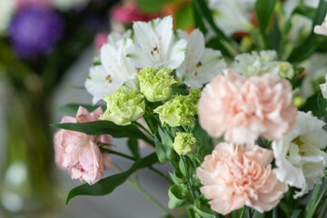 Vibrant bouquet of pink carnations and white flowers with green foliage