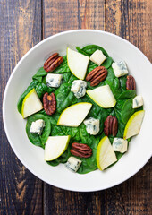 Salad with spinach, blue cheese, pear, and nuts. Healthy eating. Vegetarian food.