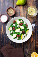 Salad with spinach, blue cheese, pear, and nuts. Healthy eating. Vegetarian food.