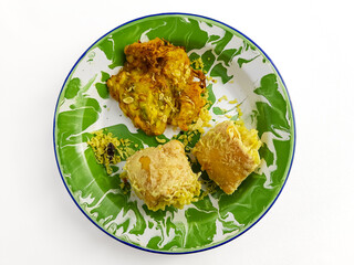 Indonesian fried bakwan and stuffed tofu on green enamel plate flat lay