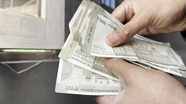 Closeup footage of hands counting cash and money. An employee counting indian rupees or indian currency money which he get from Bank. Person having cash in his hand for billing and payment.