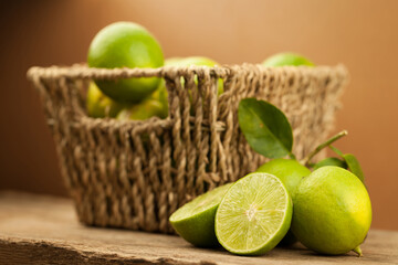 Fresh Green Limes in a Woven Basket on Rustic Wooden Table