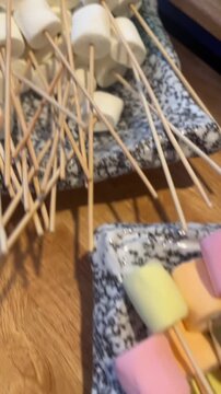 vertical video of colorful pastel marshmallow sticks on skewers showing sweet playful snack style
