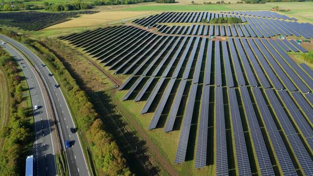 Drone aerial of solar farm and highway with moving vehicles, Leicester region, East Midlands, United Kingdom