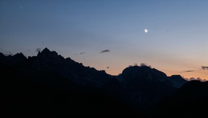 Serene Twilight Landscape with Mountains and Moon in the Sky