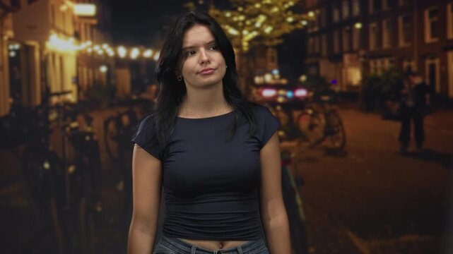 Dark-haired woman wearing navy crop top looks up with slight head tilt on street under warm lights; quiet contemplation.