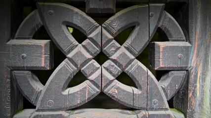 Detailed view of wood carving pattern, geometric, traditional and artistic. Architecture detail shows craftsmanship, wood texture and symmetric design.