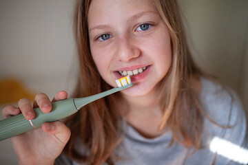 Preteen girl brushing teeth in natural lifestyle scene