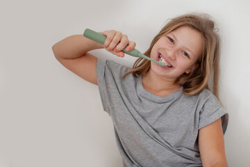 Preteen girl brushing teeth in natural lifestyle scene