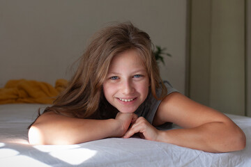 Happy Teenage Girl Relaxing in Bed in the Morning