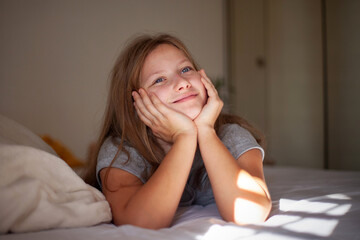 Happy Teenage Girl Relaxing in Bed in the Morning