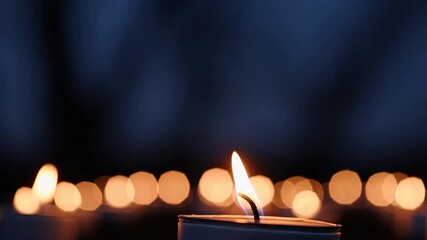 Candle flame burns softly at night. Close-up of wax candle glowing in dark. Fire and heat radiate gentle light. Warm glow and flickering fire create contrast between flame, night, wax, and burn. - Powered by Adobe