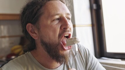 Thoughtful man with dreadlocks eating meal by the window - Powered by Adobe