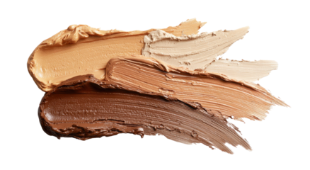 Swatches of various foundation shades smeared on a black surface, showcasing skin tones
