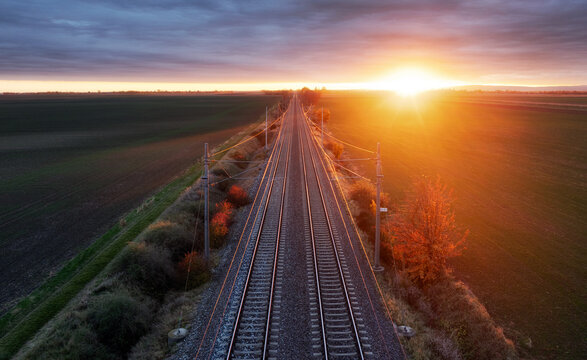 The railway through the autumn forest at dawn. Drone view