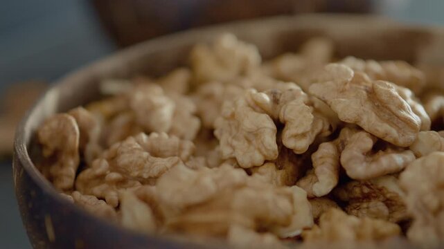 A close-up view of a bowl filled with fresh walnut kernels highlights their rich texture and healthy fats. Perfect for snacking or adding to dishes for extra nutrition.