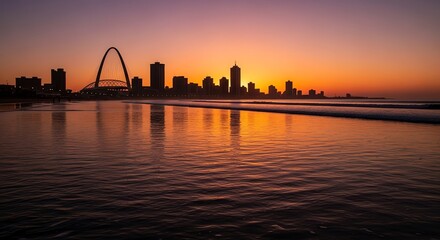 Obraz premium City skyline at sunset over ocean water